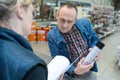 customer in hardware store enquiring about spray can Royalty Free Stock Photo