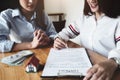 The customer holds a pen and reads the conditions in order to sign a house purchase contract with home insurance