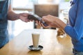 Customer making payment through payment terminal at counter in cafÃÆÃÂ© Royalty Free Stock Photo