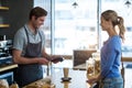 Customer making payment through payment terminal at counter Royalty Free Stock Photo