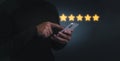 Customer man hand pressing on smartphone screen with gold five star rating feedback Royalty Free Stock Photo