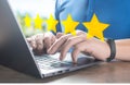 customer man hand typing on keyboard laptop to giving 5 star to review service. Five star rating feedback icon level for