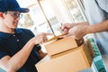 Customer Man signature in clipboard to receive package from professional delivery man at home Royalty Free Stock Photo