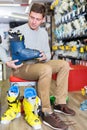 Customer man is trying on new boots for skiing