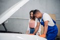 A mechanic inspects a car engine in the presence of a client Royalty Free Stock Photo