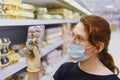 A customer in a medical mask chooses quail eggs in a store Royalty Free Stock Photo