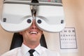 Customer of a optometrist or optician looking through phoropter