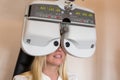 Customer of a optometrist or optician looking through phoropter