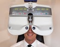 Customer of a optometrist or optician looking through phoropter