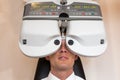 Customer of a optometrist or optician looking through phoropter