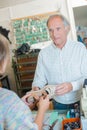 Customer passing shoe to cobbler Royalty Free Stock Photo