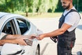 Customer paying by cash to smiling gas station operator