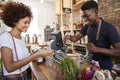 Customer Paying For Shopping At Checkout Of Sustainable Plastic Free Grocery Store