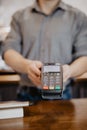 Barista hold card reader. Customer paying for their order with a credit card in a cafe. Bartender holding a credit card reader Royalty Free Stock Photo