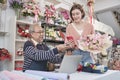 Customer payment by scanning phone application to elderly male florist owner Royalty Free Stock Photo