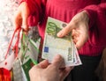 Customer pays euro bills cash while shopping.