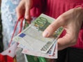 Customer pays euro bills cash while shopping.