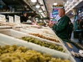 Customer pulls credit card from wallet in front of pasta display