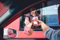 Customer receiving hamburger and ice cream after order and buy it from McDonald`s drive thru service