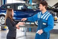 Customer receiving the keys of her new car from a service mechanic Royalty Free Stock Photo