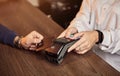 The customer`s hand pays for a contactless credit card with NFC technology. Bartender with a Credit Card reader. Focus on hands Royalty Free Stock Photo