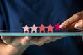 Customer satisfaction survey, give 5 star rating for review, positive feedback good experience, woman holding five star on tablet Royalty Free Stock Photo