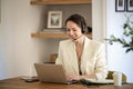 Confident woman with headshet and laptop working at home Royalty Free Stock Photo