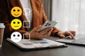 Customer service evaluation concept. woman Show face smile emoticon show on virtual screen from hand.looking at smart phone, Royalty Free Stock Photo