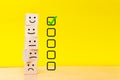 Customer service evaluation and satisfaction survey concepts. Images of emoticons on wooden cubes. Yellow background with a copy