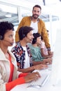 Customer service executive trainer assisting her team at desk in office Royalty Free Stock Photo