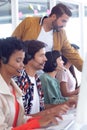 Customer service executive trainer assisting her team at desk Royalty Free Stock Photo