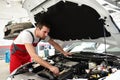 customer service in the garage - mechanic checks and repairs the engine of a car