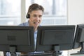 Customer Service Representative Using Multiple Screens Royalty Free Stock Photo