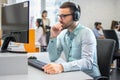 Customer service support operator man with headphones and microphone listening to his client in call center Royalty Free Stock Photo