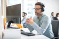 Customer service support operator man with headphones and microphone listening to his client in call center. Royalty Free Stock Photo