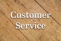 `Customer Service` white text on a wooden background.