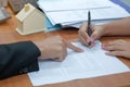 customer signs home loan contract with real estate agent