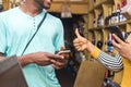 customer successfully makes payment via mobile transfer in a retail store, and the female merchant gives a thumbs up to show it