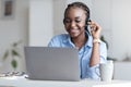 Customer Support. Black woman manager wearing headset and using laptop in office Royalty Free Stock Photo