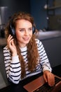Customer support service call center manager speaking, working from home. Curly woman with headset enjoys listening to