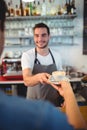 Customer taking coffee from happy waiter at cafe Royalty Free Stock Photo