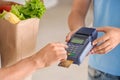 Customer using bank terminal to pay for food delivery, closeup