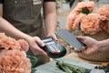 Customer using phone for payment in flower shop. Nfc payment. Royalty Free Stock Photo