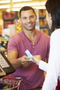 Customer Using Vouchers At Supermarket Checkout Royalty Free Stock Photo