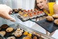 Customer woman in confectionery choosing which cake to buy