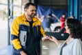 Customer women happy giving car key to mechanic worker for car service fix problem auto center workshop center Royalty Free Stock Photo