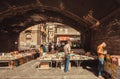 Customers of antique market reading old books under city bridge, the place for weekend flea market