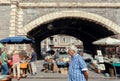 Customers of antique market walking around vintage stuff stands, flea market vintage furniture