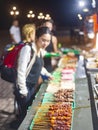 Customers choose from trays of barbecue food for sale,at night,along Rizal Boulevard