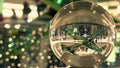 Customers in Christmas and New Year decorated shopping mall. Distorted view through the glass ball Royalty Free Stock Photo